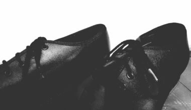 a pair of black shoes sitting on top of a wooden floor